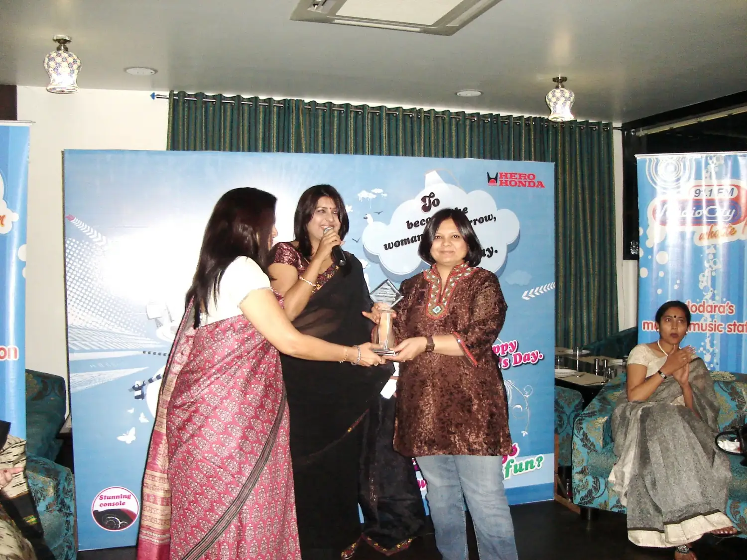Men lighting ceremonial lamp at event with ITT banner in background